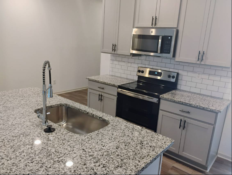 Kitchen with polished granite counters and stainless appliances