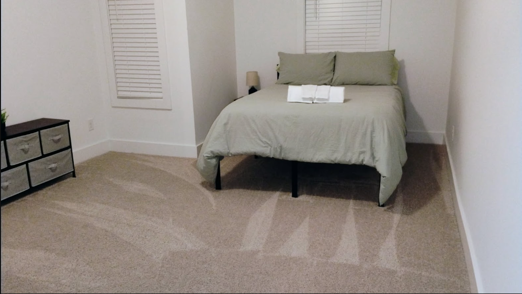 Bedroom with vacuumed carpet showing fresh cleaning lines